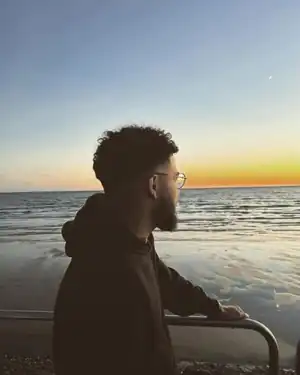 Edmond face à la mer au coucher du soleil