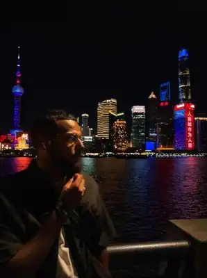 Edmond de nuit face à la skyline de Shanghai